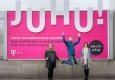 Grund zur Freude: Monika Ornik (EPAMEDIA), Emmanuel Buchholz (MediaCom) und Katharina Kröll (T-Mobile Austria) präsentieren die Formatsprengung am EPAMEDIA Plakat für die neue JUHU!-Kampagne © EPAMEDIA