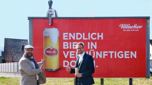 Roland Simonetitsch (Regionalleiter EPAMEDIA Kärnten) und Peter Peschel (Leitung Marketing der Vereinigte Kärntner Brauereien AG) lassen sich die Formatsprengung auf den EPAMEDIA Flächen schmecken © EPAMEDIA
